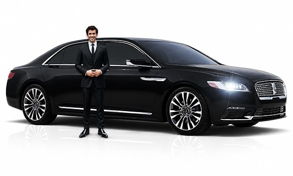 Professional chauffeur standing beside black executive sedan luxury car