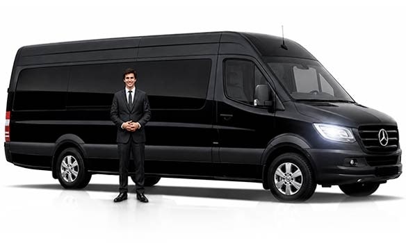 Professional chauffeur standing beside black Mercedes Sprinter van